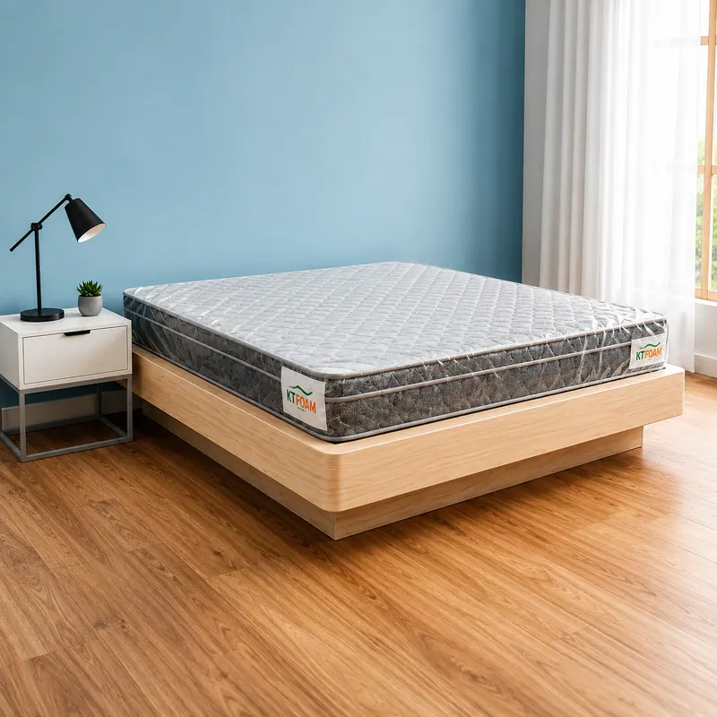 Grey quilted Ortho Fit mattress on a low wooden bed against a blue wall