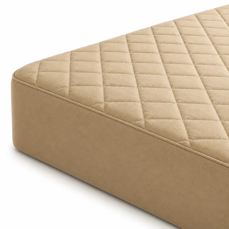 Close view of the corner of a beige diamond-quilted soft bed mattress